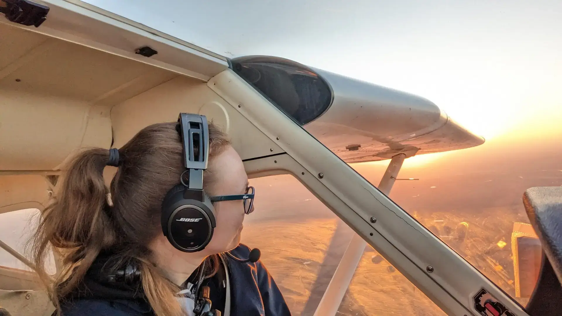 Student pilot smiling beside a training airplane at Dayton Aviation Services