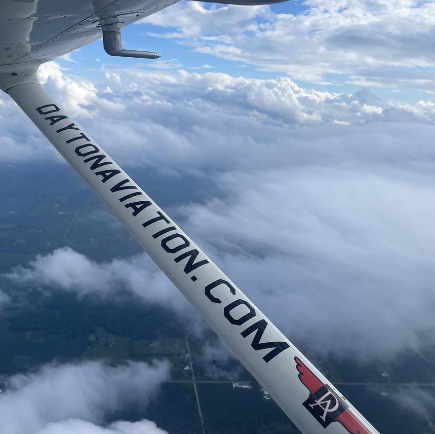 Airplane wing above clouds during private pilot training near Dayton
